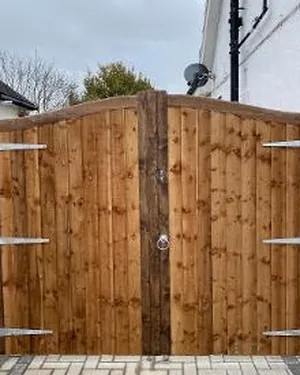 Arched timber side gate on black hinges